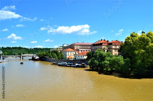 Vltava River during sunny day. Vltava River photos from Charles Bridge, Prague, Czech Republic. Blue sky and yellow river together in same photo.