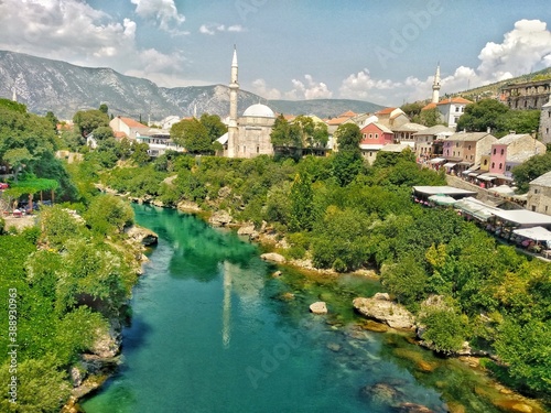 Green city of Bosnia and Herzegovina. City of Mostar, Bosnia and Herzegovina. Green Neretva River, blue sky. mosque and minaret and colorful city.