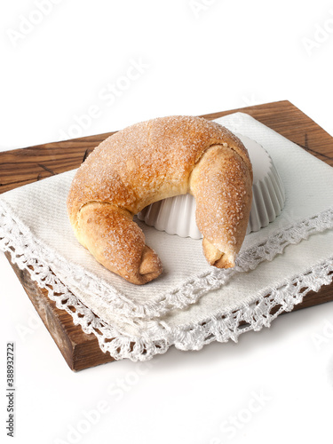 food photography of sugar coated croissants (rogalik) on wooden cutting board and vintage cloth napkin side view on a white background isolated close up