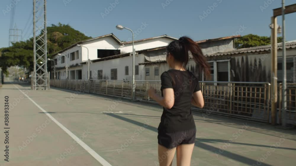 back view. Asian female runner wear black athletic sportswear running on bridge walkway in the city
back view. Asian female runner wear black athletic sportswear running on bridge walkway in the city