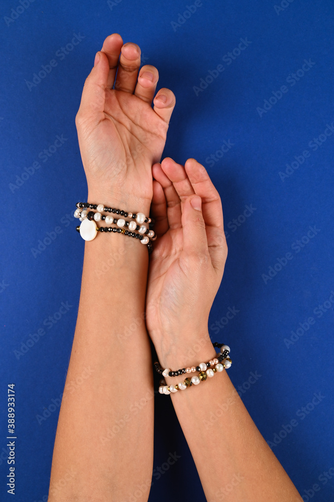Bracelets with pearls are displayed on female hands. Fashion jewelry.