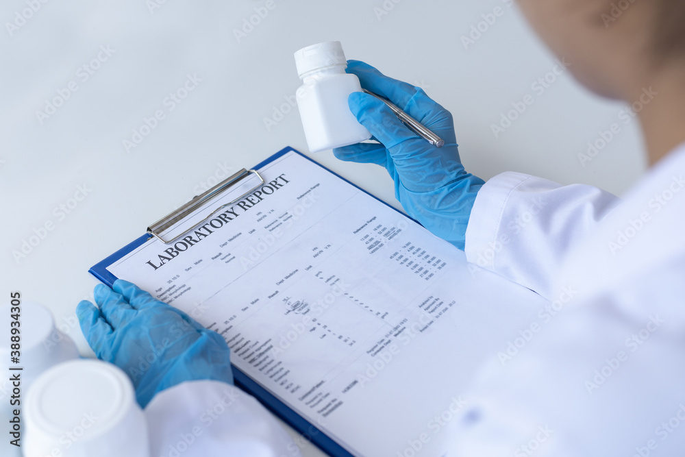Fototapeta premium Closeup portrait, Scientists in white lab coats are analyzing the vital substance of the sample drug in a lab, Medical scientist for treatment concept.