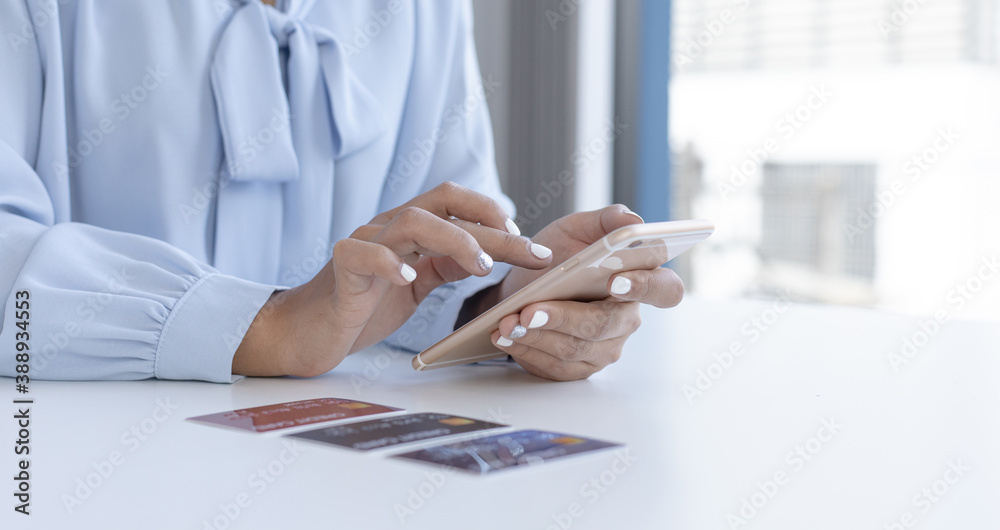 Fototapeta premium Women use smart phone to register online purchases using credit card payments.