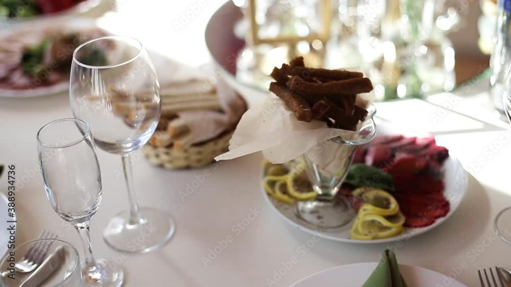 The waiter serves dishes on the festive table. Beautiful dishes on the banquet table, background The waiter serves dishes on the festive table. Beautiful dishes on the banquet table, background