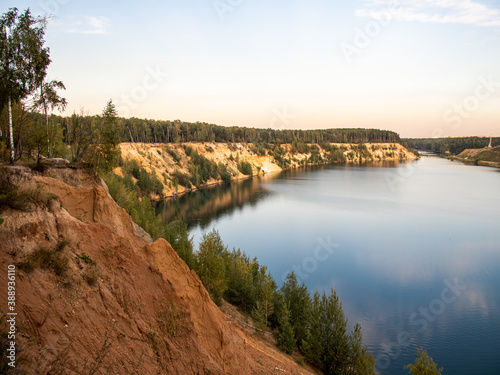cliffs on a sandy quarry water and forest on the Sunset