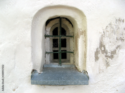 window with a fore vailated metal grille in an ancient monastery © Андрей Знаменский