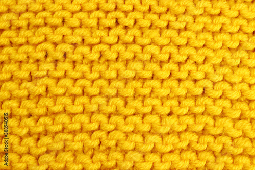 Knitted background of yellow wool threads