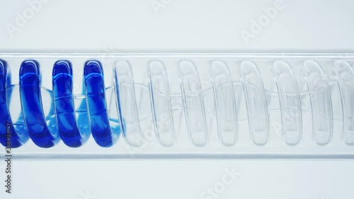 The flask is a tube with a spiral inside. Chemical reactions. Scientific experiment. Blue liquid flows in a spiral into the flask.