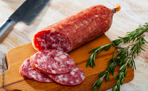 View of traditional spanish smoked salchichon sausage on wooden cutting board photo