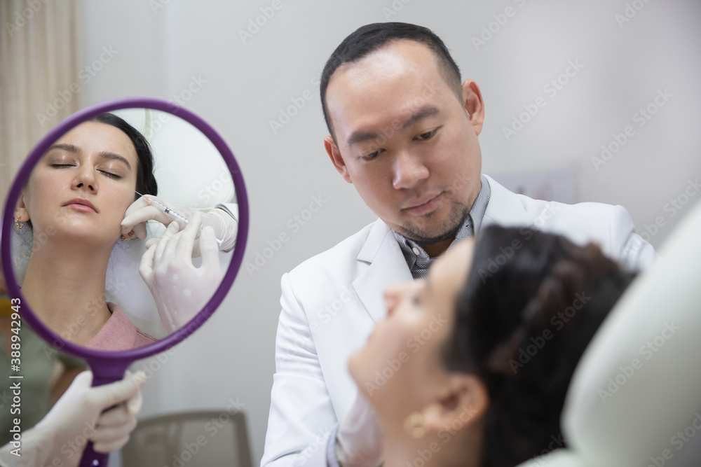 Fototapeta premium Young woman getting beauty facial injections in salon. Beautician makes cosmetic injection into the female patient face. Beauty injections, mesotherapy, revitalization and rejuvenation