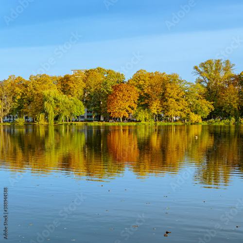 Perfectly reflected autumn foliage and blue sky on the calm waters of the lake.