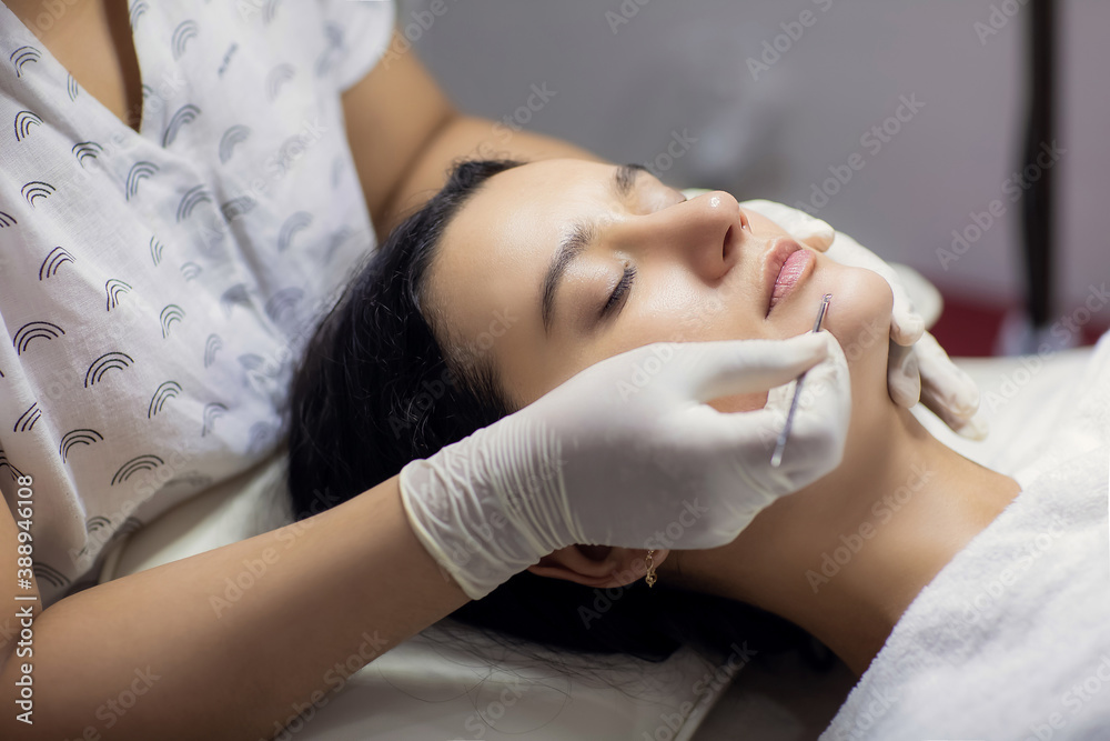 Blackhead cleansing on woman face during facial treatment at beauty