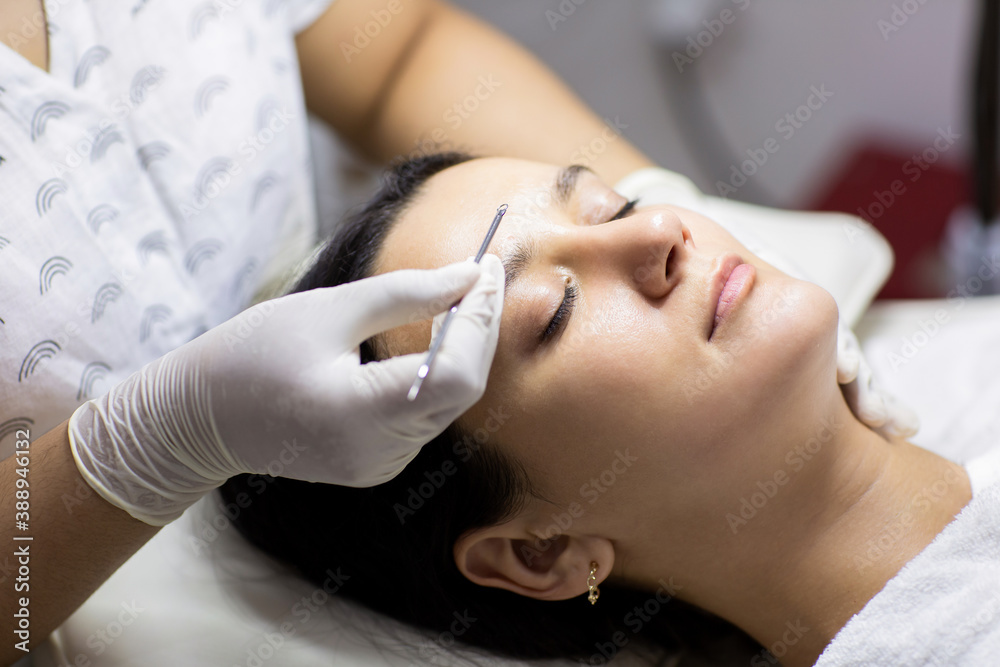 Blackhead cleansing on woman face during facial treatment at beauty clinic. Professional acne