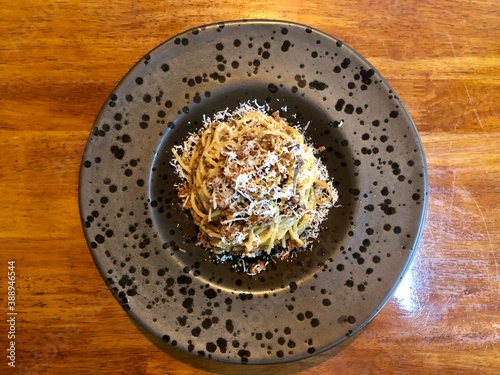 Italian pasta spaghetti bolognese served on fancy plate with parmesan cheese.