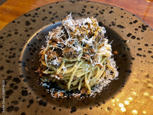 Italian pasta spaghetti bolognese served on fancy plate with parmesan cheese.