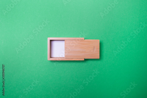 lightly open wooden box with place for you logo on green colored paper background
