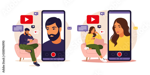 Woman and man video bloggers sitting on sofa with phone and recording video with smartphone. Different social media icons. Vector illustration in flat style.