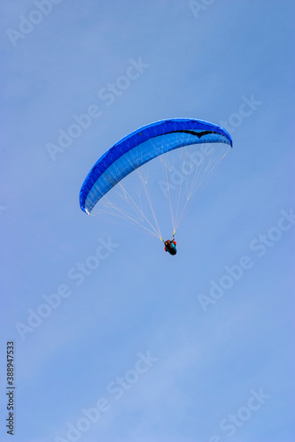 Paraglider flying at a clear blue sky