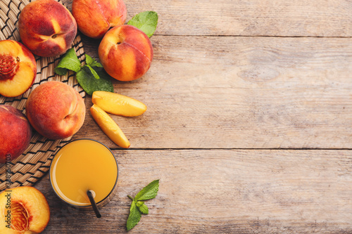 Natural peach juice and fresh fruits on wooden table, flat lay. Space for text