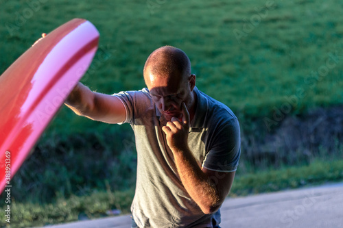 Shot of a young stressed man having trouble with his broken car looking in frustration at failed engine. Cropped shot of a young man with his broken down car on the side of a road. Man with broken car photo