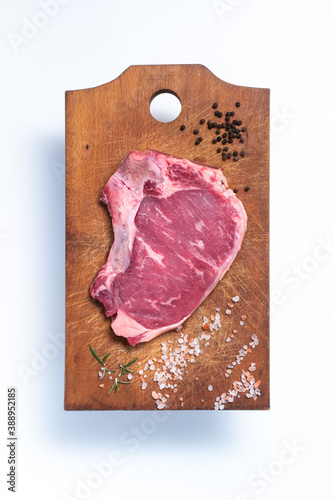 heifer steak. beef. steak on a wooden cutting board with spices, pepper, pink salt and rosemary. raw meat on wooden table. White background