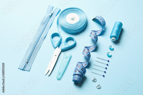 Flat lay with sewing supplies on blue background