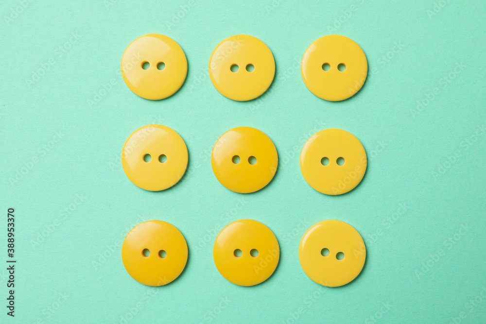 Flat lay with yellow buttons on mint background Flat lay with yellow buttons on mint background