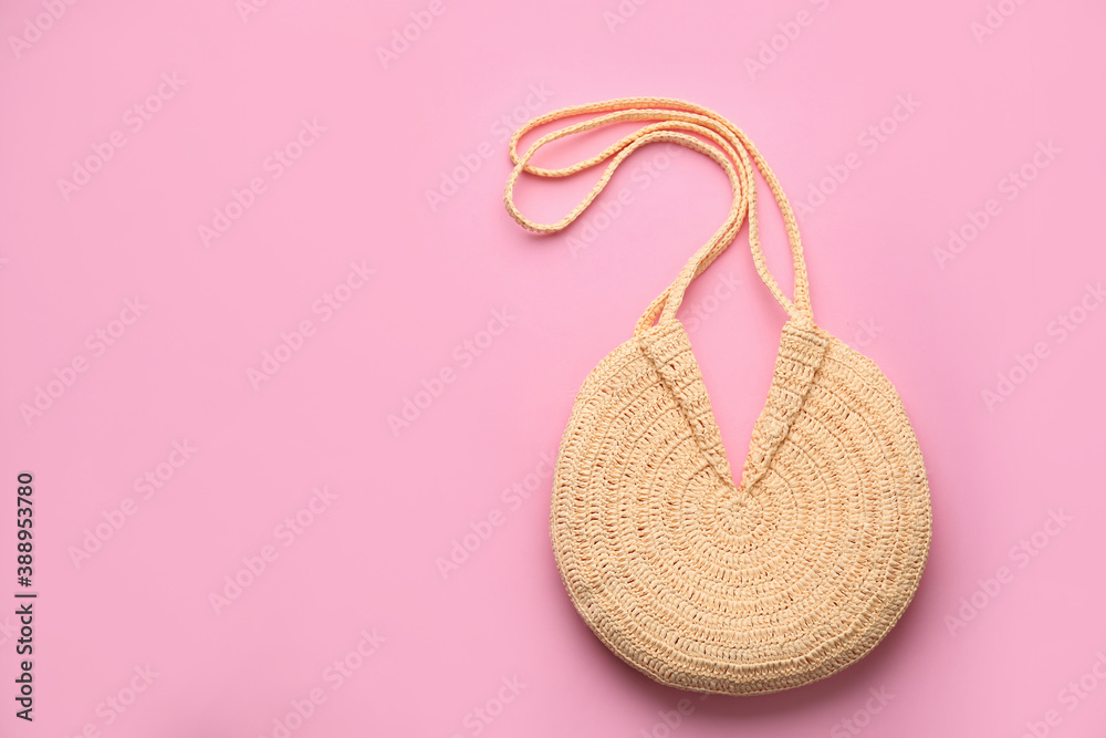 Elegant woman's straw bag on pink background, top view. Space for text