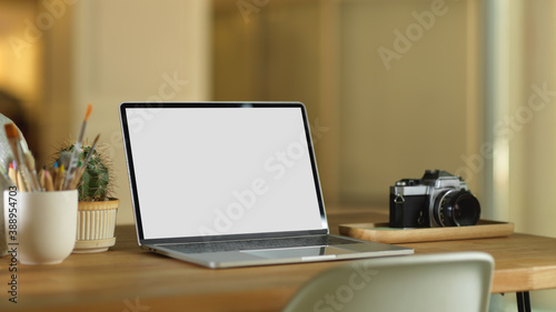 Workspace with laptop, camera and decorations on wooden table, clipping path