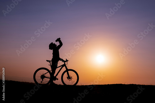 break time for the cyclist, drinking water and enjoying the sunrise
