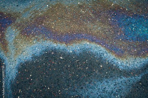 Abstract rainbow effect background, colorful gas stain on wet asphalt caused by a leak under a car or truck