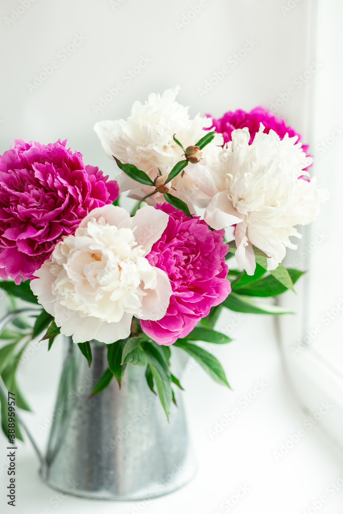 Bouquet of beautiful peonies on the windowsill. Pink and white peonies in a tin jug. Soft focus Bouquet of beautiful peonies on the windowsill. Pink and white peonies in a tin jug. Soft focus