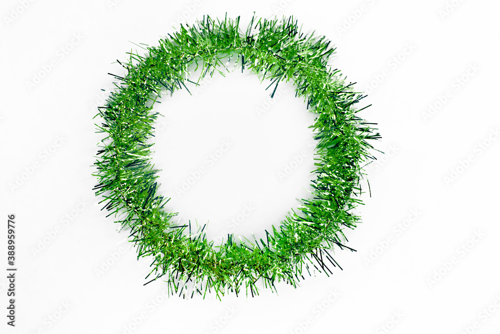 Round circle of bright green tinsel on a white background. Christmas decorations. New year concept Round circle of bright green tinsel on a white background. Christmas decorations. New year concept