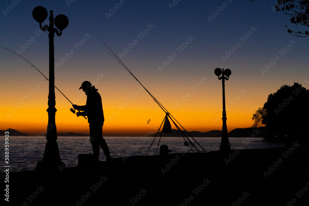 The silhoette of a fisherman in a village along the northern shore of the Peloponnese Peninsula, Greece