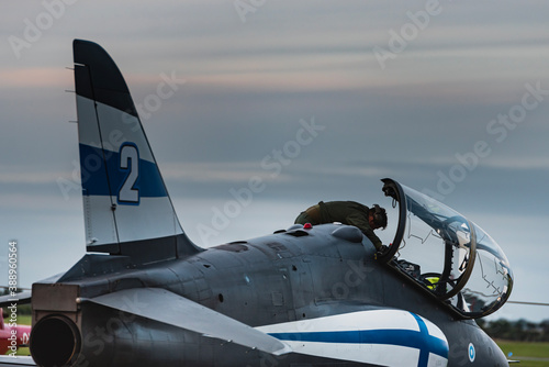 Schilderij op canvas A pilot prepares his Finnish fighter plane before taking off at twilight