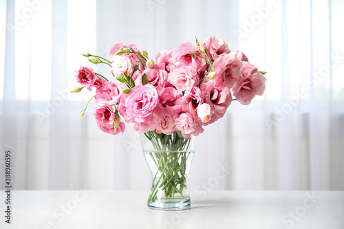 Beautiful pink Eustoma flowers in vase on table indoors