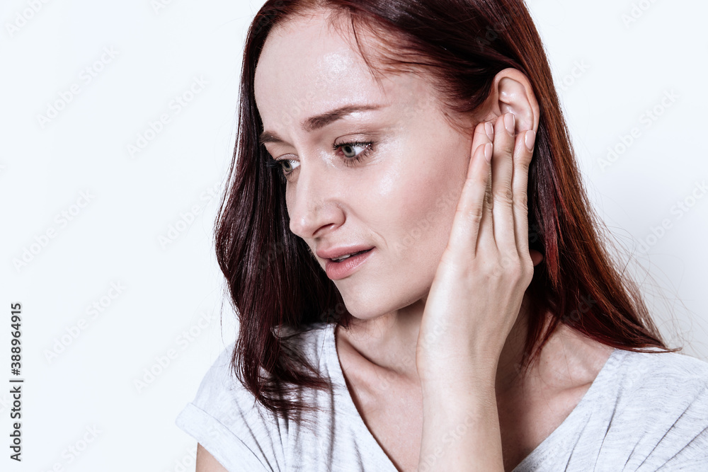 Woman on a white background with acute earache. Woman on a white background with acute earache.