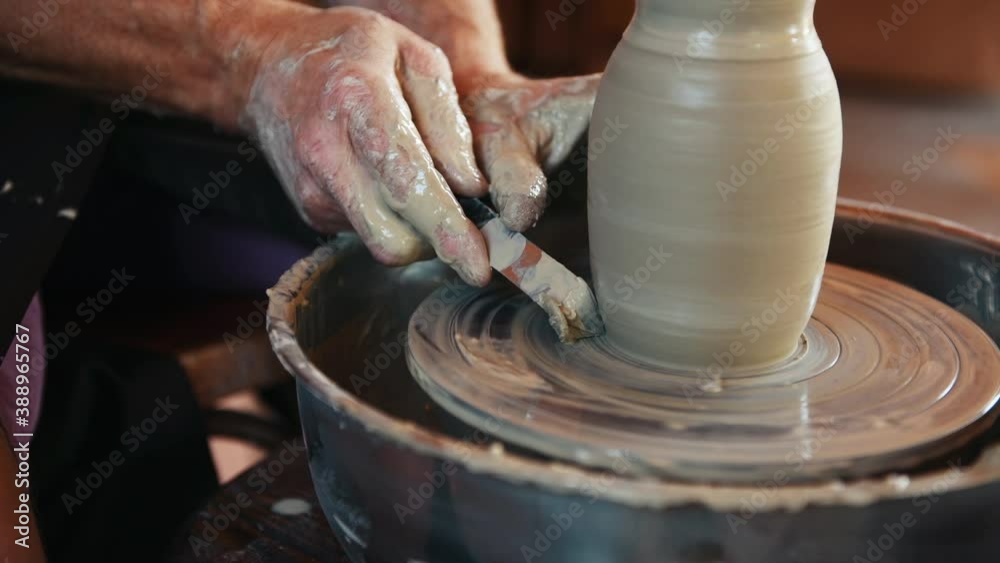 Ceramist uses potter's wheel and creates a handmade clay product. Ceramist uses potter's wheel and creates a handmade clay product.