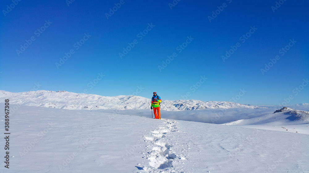 dağlarda bir kayakçı, manzara keyfi, kış mevsimi ve karlı dağlar, renkli giyinen adam