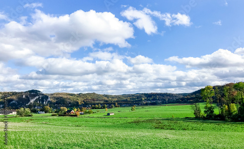 magnifique landscape in europe with green grass, blue sky and white clouds over the hill in Spring season.