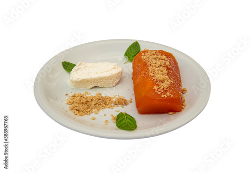 Pumpkin dessert in white plate, standing on isolated background.