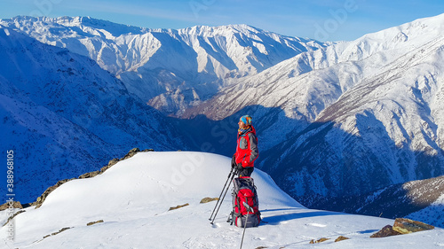 a young man in the mountains, white landscape, winter season, cold weather, hiker, mountaineer young