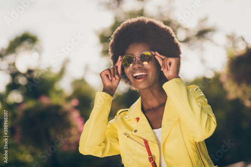 Photo portrait of happy girl touching sunglasses laughing outside