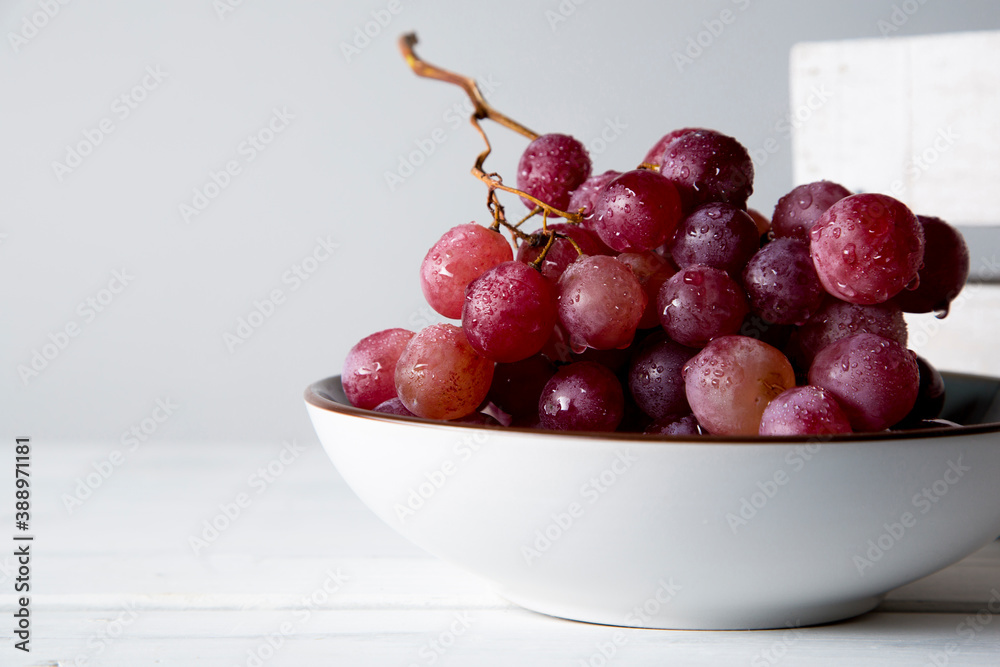 still life of red grapes on white wooden table still life of red grapes on white wooden table