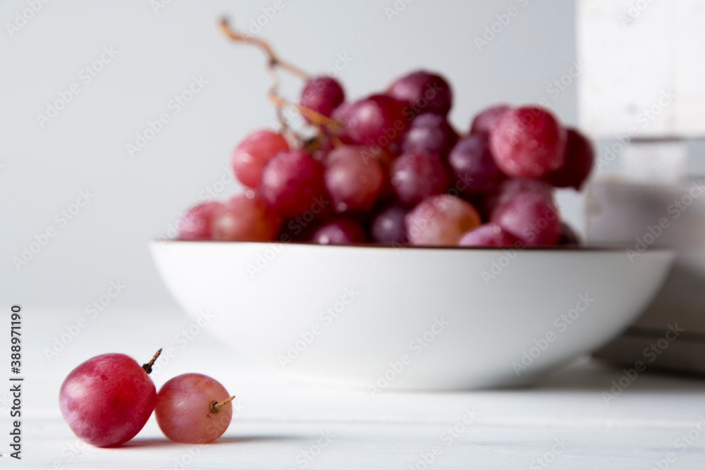still life of red grapes on white wooden table still life of red grapes on white wooden table
