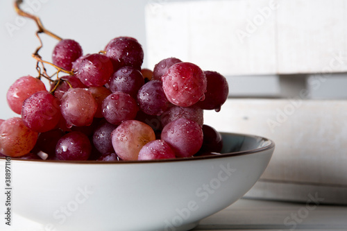 still life of red grapes on white wooden table