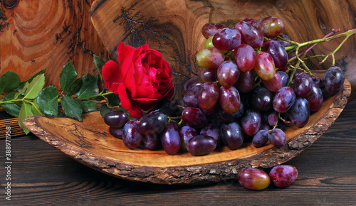 Fresh ripe grapes. Grape harvest. Handmade wooden utensils on the kitchen table. Wooden plates, bowls and dishes on the table. 