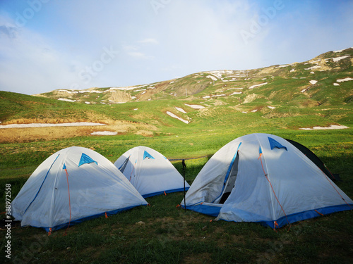 camping tents in the mountains, green meadows, colorful camping tents, nature and life 