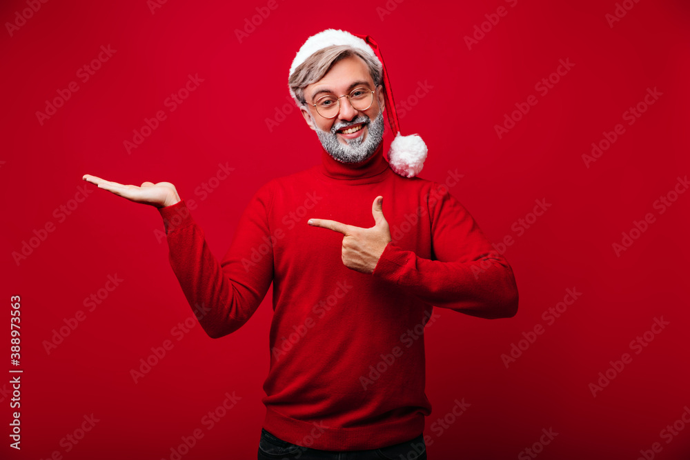 Joyful santa claus in glasses laughing on red background. Carefree grey-haired model chilling in christmas. Joyful santa claus in glasses laughing on red background. Carefree grey-haired model chilling in christmas.