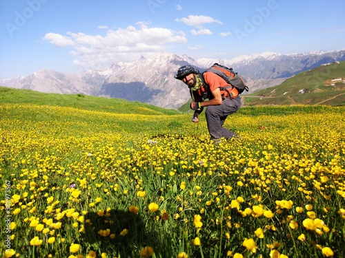 A young climber, hiker, natural landscape in green meadows and yellow flowers 